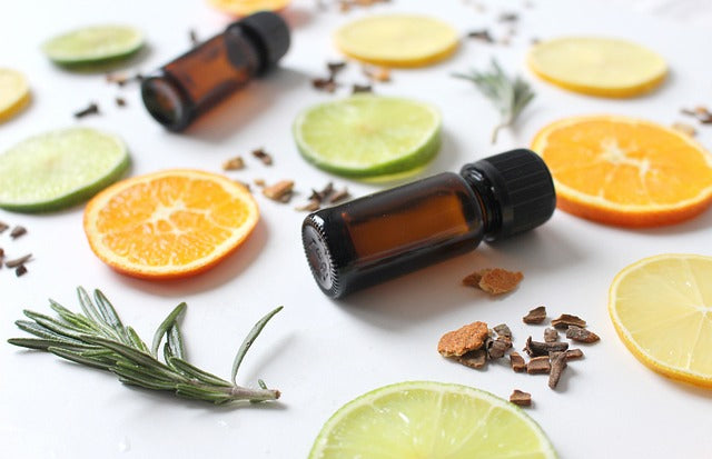 essential oil bottles amongst citrus fruits and spices