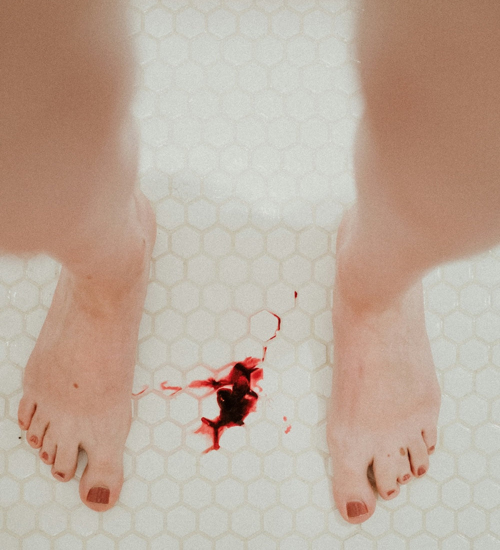 dark red menstrual blood on bathroom floor tiles