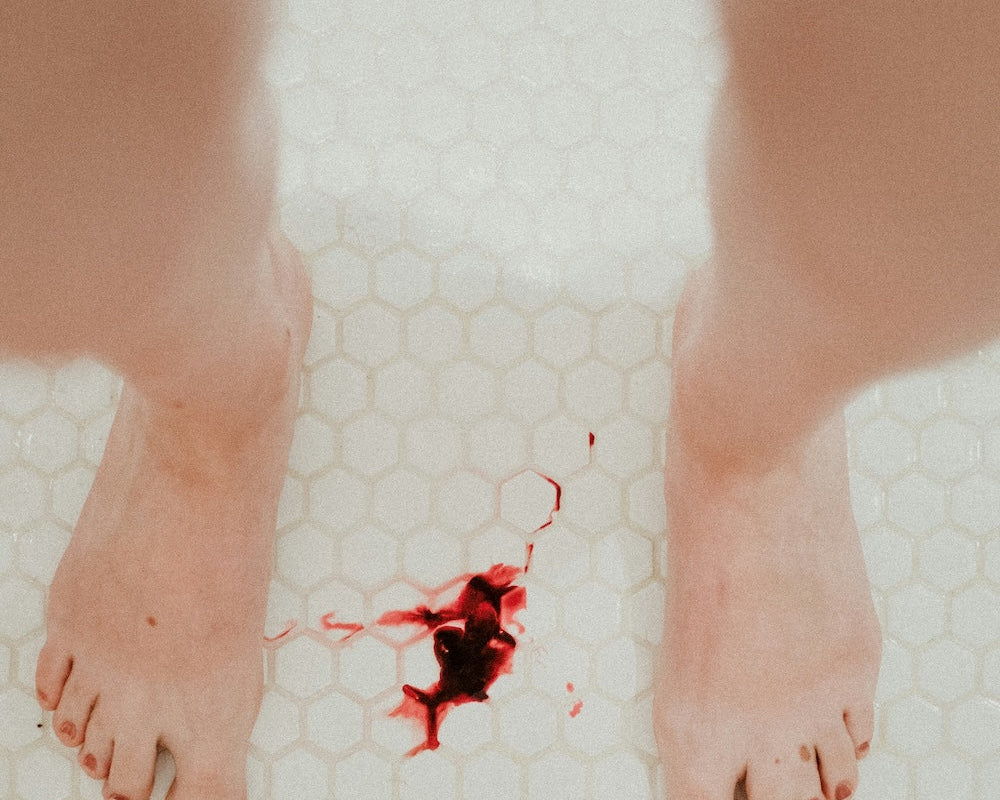 dark red menstrual blood on bathroom floor tiles