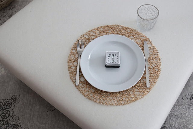 A table setting with a clock on the plate