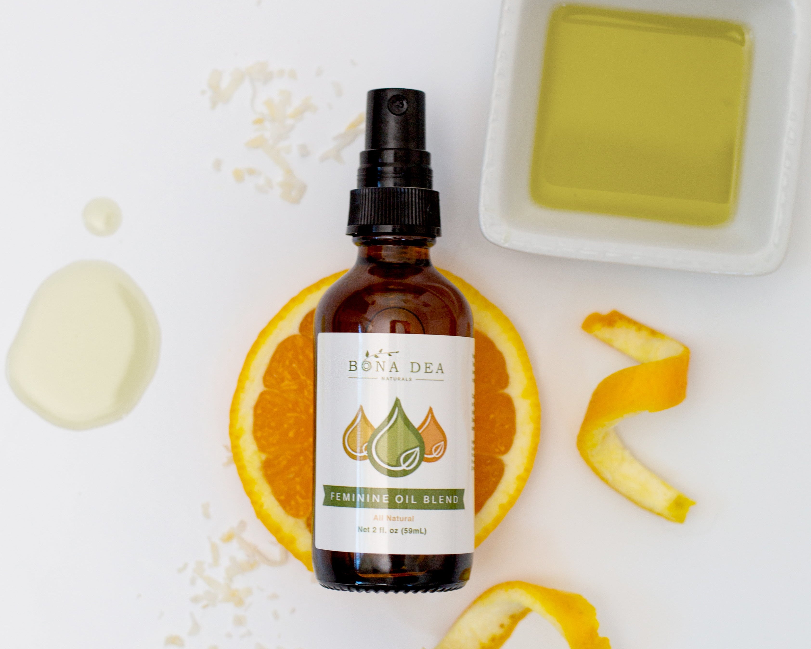 Bona Dea Naturals Feminine Oil pictured with orange, coconut, and calendula