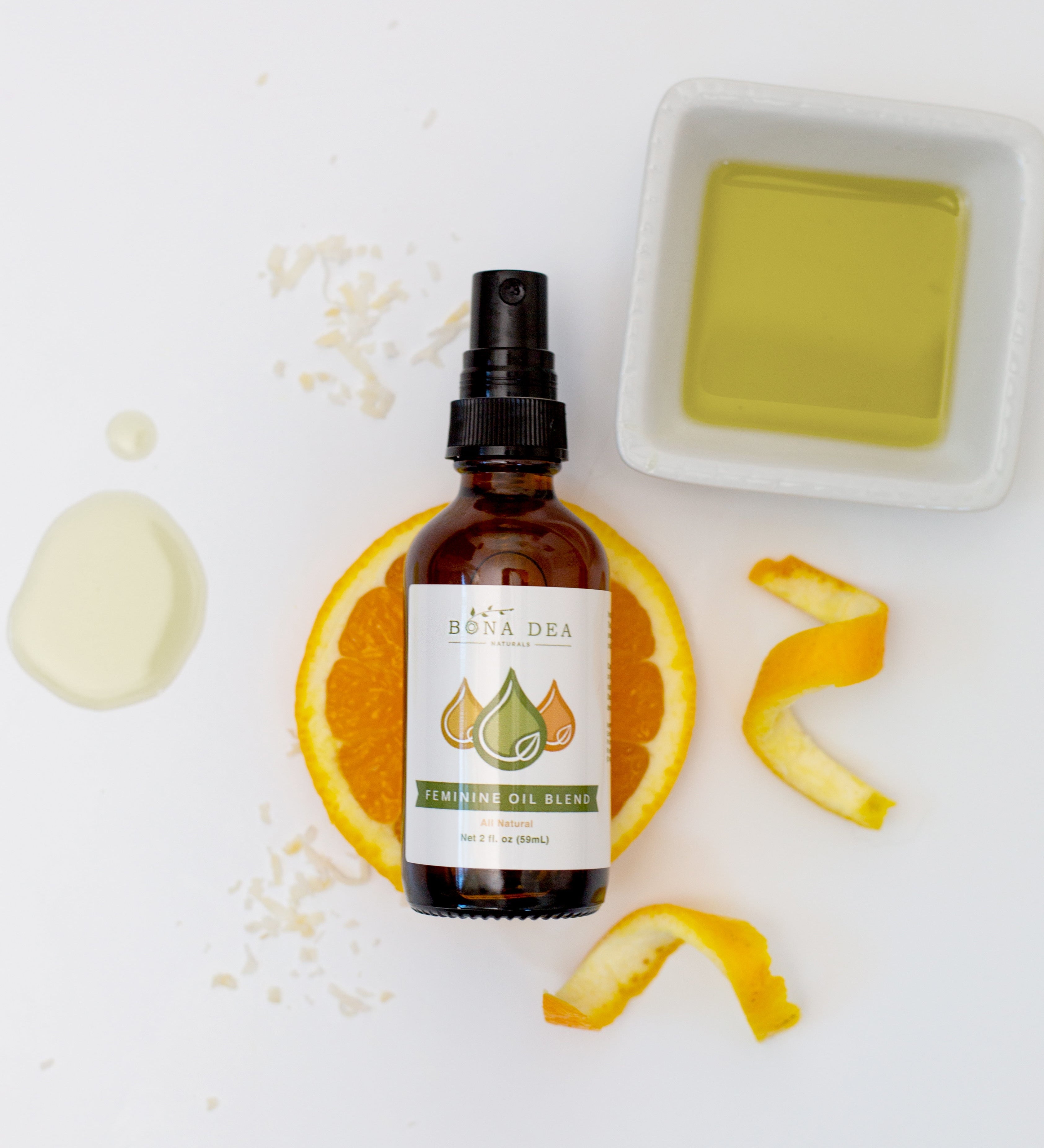 Bona Dea Naturals Feminine Oil pictured with orange, coconut, and calendula